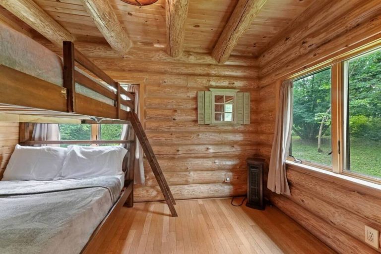 Bunk bed bedroom with forest-view window in Evart, Michigan — Coyote Fire Retreat, hosted by Roam