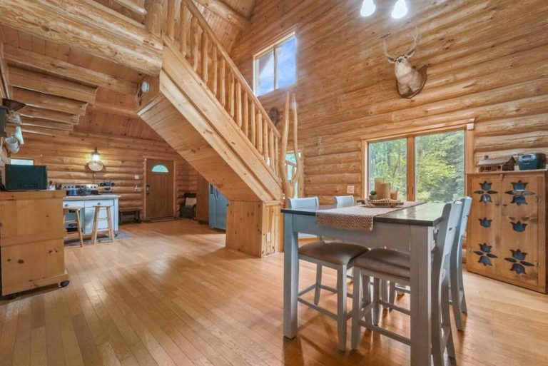 Open dining and kitchen area in log cabin in Evart, Michigan — Coyote Fire Retreat, hosted by Roam