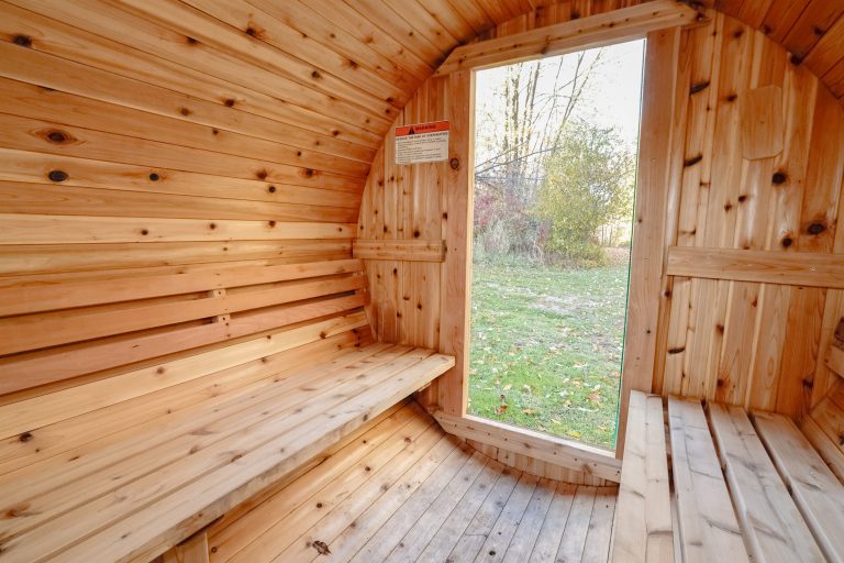 Sauna interior with wood benches and heater in this Evart, Michigan cabin — Coyote Fire Retreat, hosted by Roam