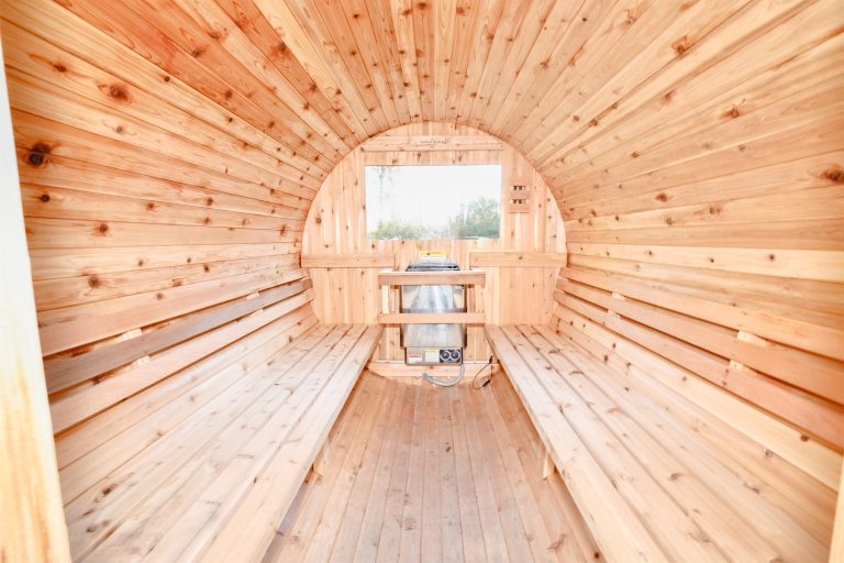 Barrel sauna exterior with open door in this Evart, Michigan cabin — Coyote Fire Retreat, hosted by Roam