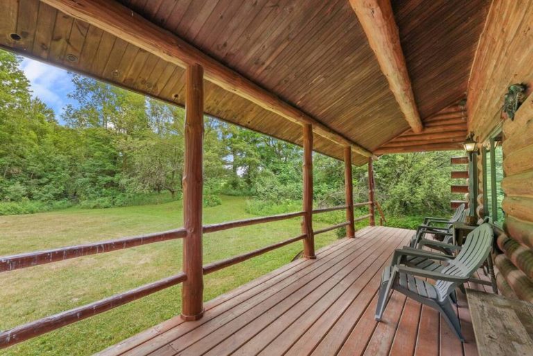 An edge-to-edge porch with covered roof allows for outdoor dining and escape from the summer sun, or a burst of rain.