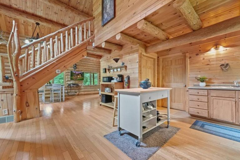 Log staircase and open-loft kitchen area in Evart, Michigan — Coyote Fire Retreat, hosted by Roam