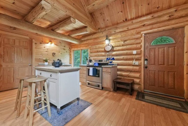 Kitchen island and front door in log cabin in Evart, Michigan — Coyote Fire Retreat, hosted by Roam