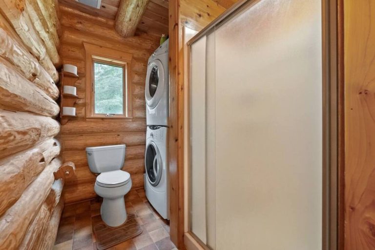 Bathroom with toilet and stacked washer-dryer in Evart, Michigan — Coyote Fire Retreat, hosted by Roam