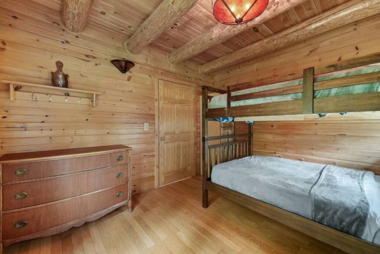 Bedroom with bunk bed and dresser in log cabin in Evart, Michigan — Coyote Fire Retreat, hosted by Roam