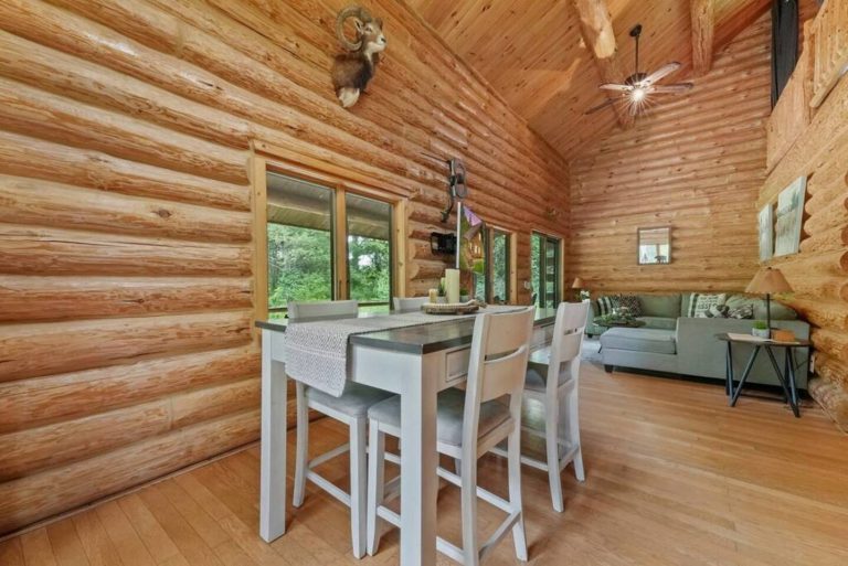 Dining table and living area in log cabin in Evart, Michigan — Coyote Fire Retreat, hosted by Roam