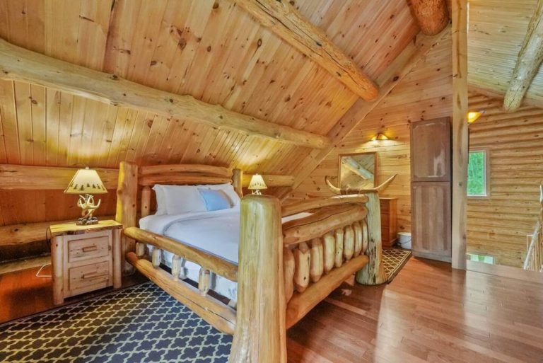A comfortable queen size bed on a hand-made artisan log timber frame anchors the room while rustic furniture finishes this loft space.