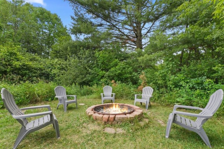 A brick construction firepit nestled between the trees and just far away enough from the home that the kids can sleep inside while the parents can enjoy some peace and quiet.