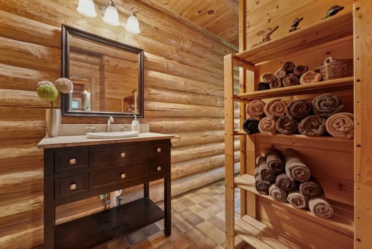 Log cabin bathroom vanity and towel shelving in Evart, Michigan — Coyote Fire Retreat, hosted by Roam