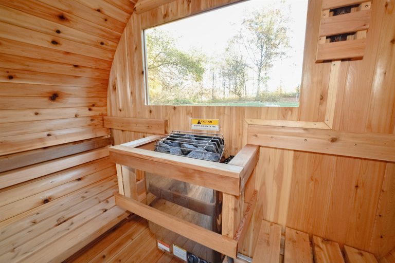 Sauna interior with benches facing a window in this Evart, Michigan cabin — Coyote Fire Retreat, hosted by Roam