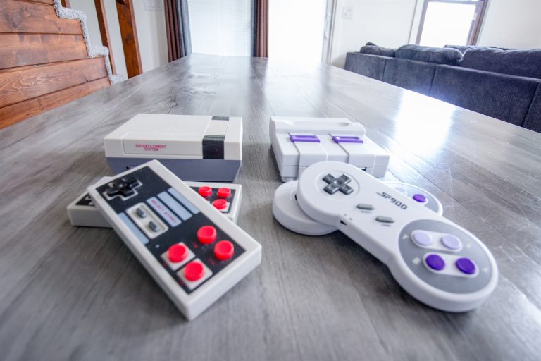 Retro game console and controllers on the dining table in Evart, Michigan — Coyote Fire Retreat, hosted by Roam