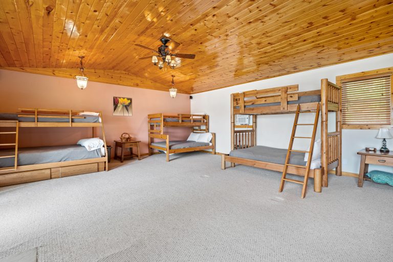 Bunkroom with multiple bunk beds in Reed City, Michigan house — Lakeside Lodge Retreat, hosted by Roam