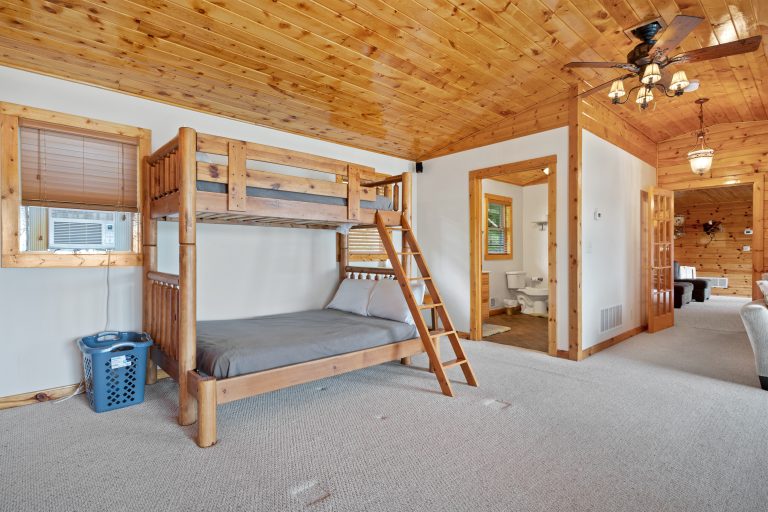 Bunk room with wood ceiling House in Reed City, Michigan — Lakeside Lodge Retreat, hosted by Roam