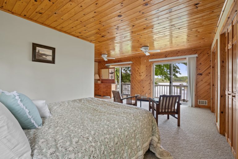 Bedroom with lake-view balcony House in Reed City, Michigan — Lakeside Lodge Retreat, hosted by Roam
