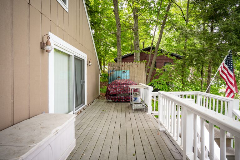 Wooded back deck with gas grill House in Reed City, Michigan — Lakeside Lodge Retreat, hosted by Roam