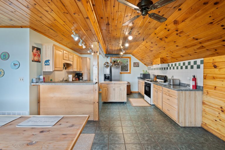 Kitchen and dining loft with pot rack in Reed City, Michigan house — Lakeside Lodge Retreat, hosted by Roam