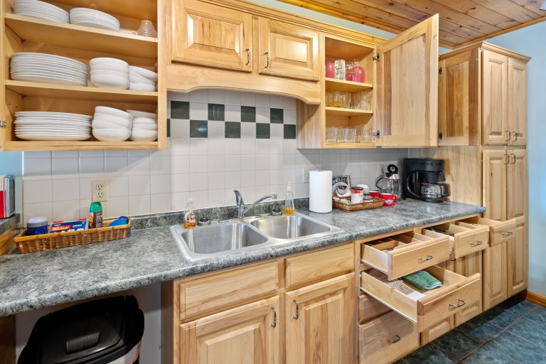 Kitchen with open shelving and double sink in Reed City, Michigan house — Lakeside Lodge Retreat, hosted by Roam