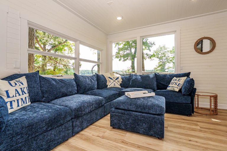 Sectional living room with lake-view windows in this Mecosta, Michigan cabin — Silent Waters Retreat, hosted by Roam