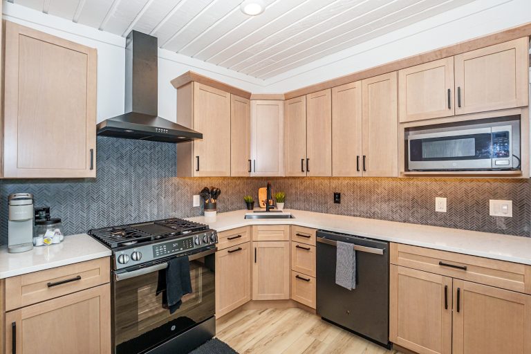 Wood cabinetry kitchen with gray tile backsplash in this Mecosta, Michigan cabin — Silent Waters Retreat, hosted by Roam