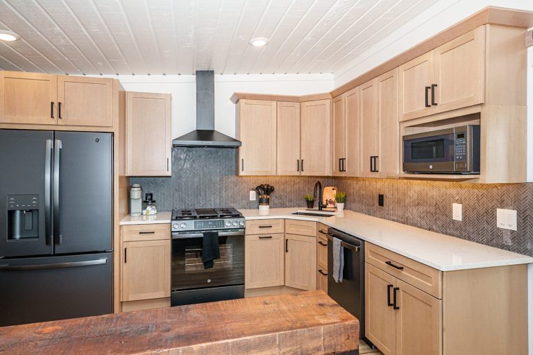 Kitchen with black fridge and wood table in this Mecosta, Michigan cabin — Silent Waters Retreat, hosted by Roam