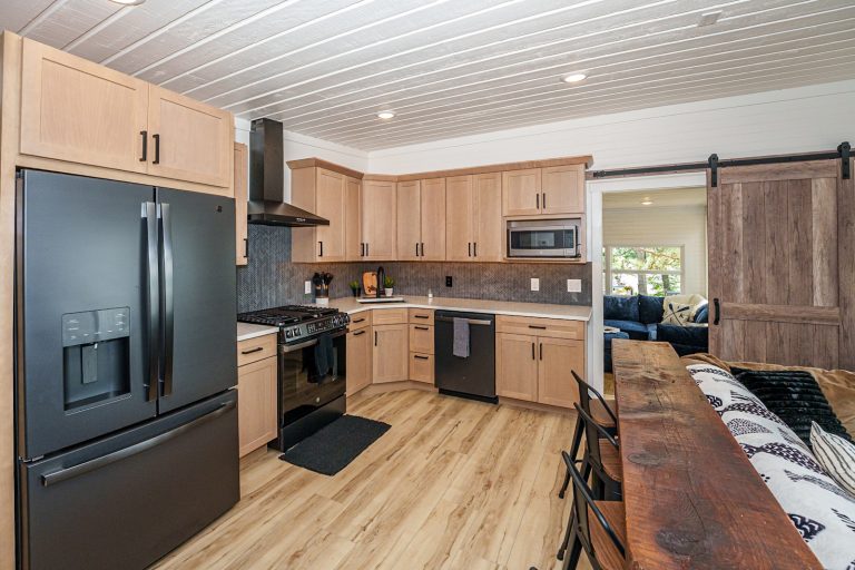 Kitchen with black stainless appliances Cabin in Mecosta, Michigan — Silent Waters Retreat, hosted by Roam