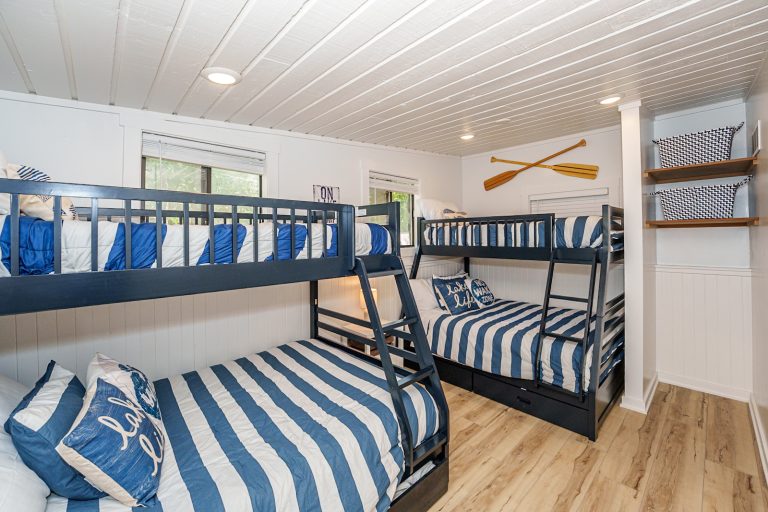 Bunk room with navy striped bedding in this Mecosta, Michigan cabin — Silent Waters Retreat, hosted by Roam