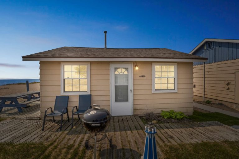 Exterior of the cabin at dusk Cabin in Oscoda, Michigan — Barefoot Beach Cabin #4, hosted by Roam