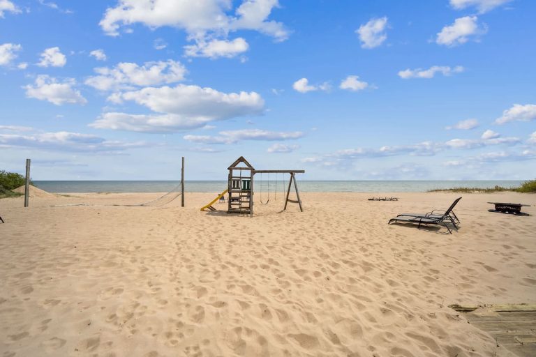Beach playground and lounge chairs by the lake in Oscoda, Michigan — Barefoot Beach Cabin #4, hosted by Roam