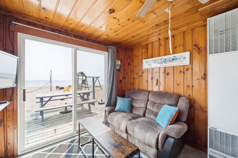 Living room with sliding door to the beach Cabin in Oscoda, Michigan — Barefoot Beach Cabin #4, hosted by Roam