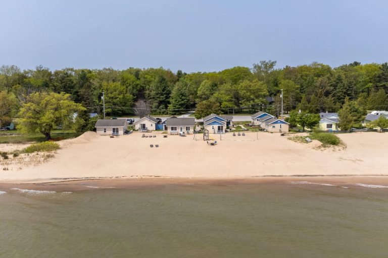 Aerial beachfront row of cottages Cabin in Oscoda, Michigan — Barefoot Beach Cabin #4, hosted by Roam