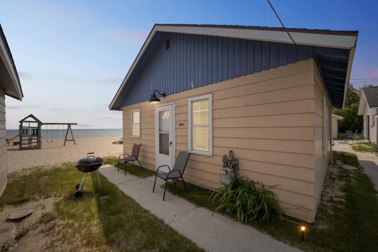 Cottage exterior at dusk Cabin in Oscoda, Michigan — Barefoot Beach Cabin #5, hosted by Roam