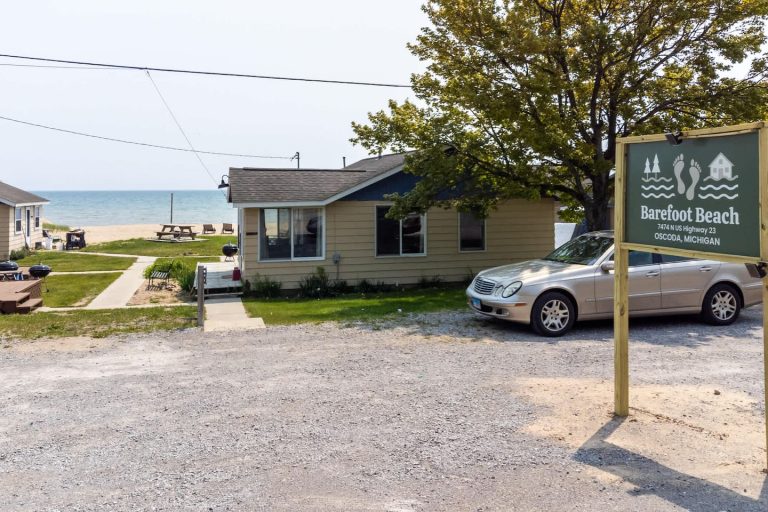 Exterior with entrance sign near the beach Cabin in Oscoda, Michigan — Barefoot Beach Cabin #5, hosted by Roam
