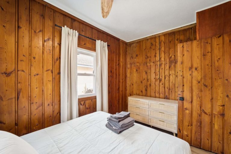 Wood-paneled bedroom with dresser Cabin in Oscoda, Michigan — Barefoot Beach Cabin #6, hosted by Roam
