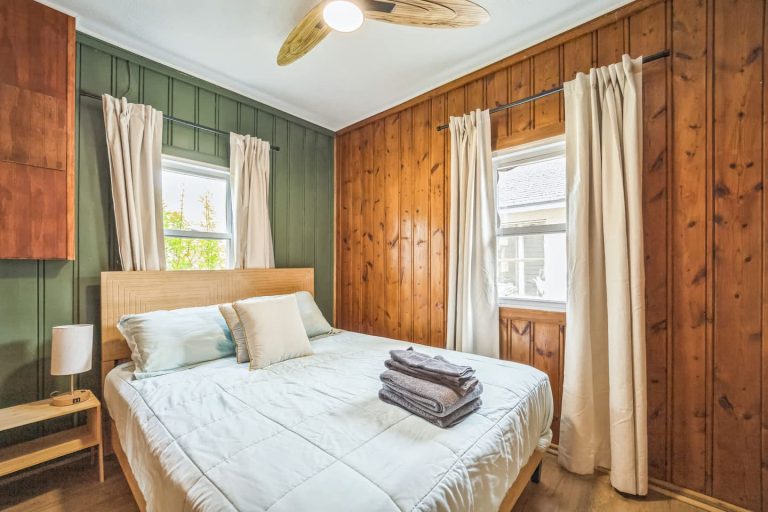 Bedroom with wood paneling, green wall Cabin in Oscoda, Michigan — Barefoot Beach Cabin #6, hosted by Roam