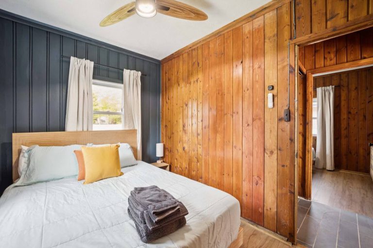 Bedroom with navy accent wall Cabin in Oscoda, Michigan — Barefoot Beach Cabin #6, hosted by Roam