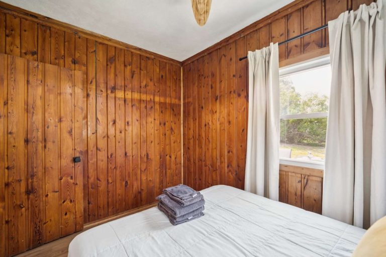 Wood-paneled bedroom with closet Cabin in Oscoda, Michigan — Barefoot Beach Cabin #6, hosted by Roam