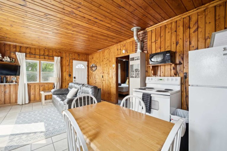 Living room and kitchenette Cabin in Oscoda, Michigan — Barefoot Beach Cabin #6, hosted by Roam