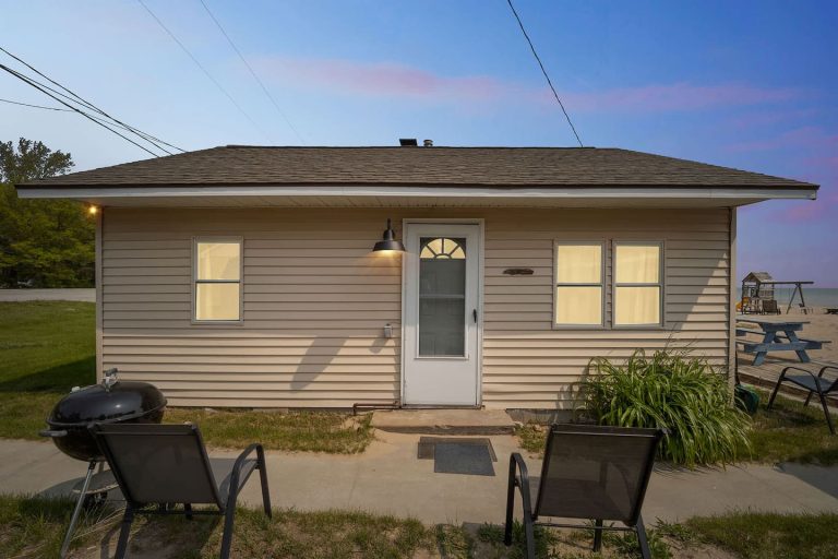 Cottage exterior at dusk near the beach Cabin in Oscoda, Michigan — Barefoot Beach Cabin #6, hosted by Roam
