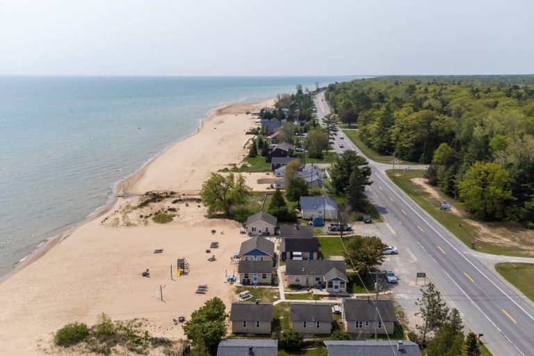 Aerial shoreline road and beach cottages Cabin in Oscoda, Michigan — Barefoot Beach Cabin #6, hosted by Roam