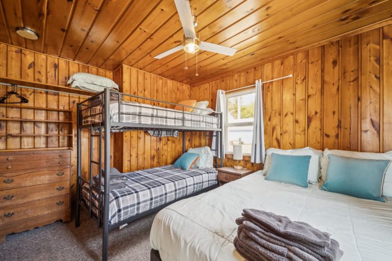 Bedroom with bunk and queen beds Cabin in Oscoda, Michigan — Barefoot Beach Cabin #7, hosted by Roam